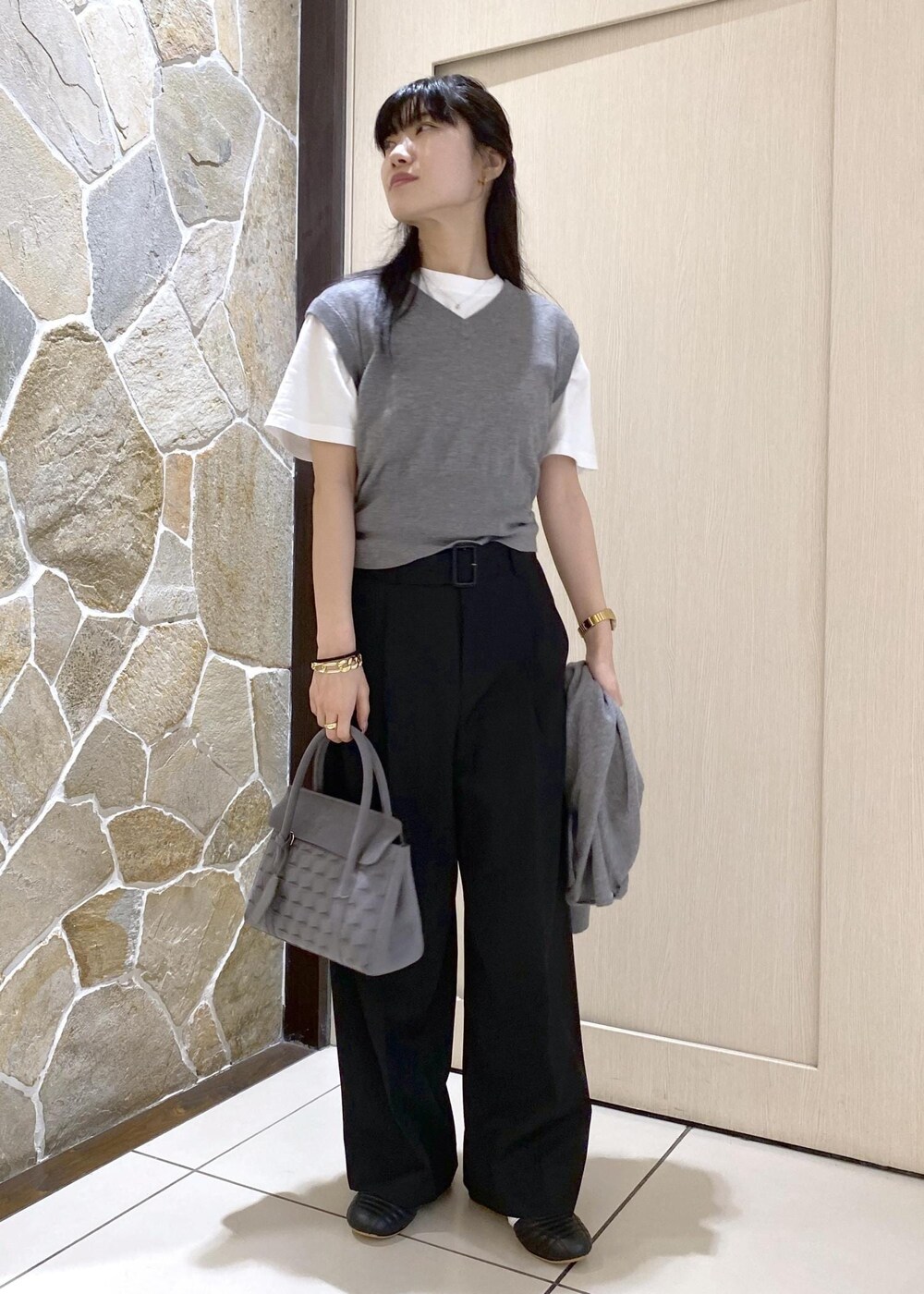 ブラック系のスニーカー、グレー系のニット/セーター、ブラック系のスラックスを着用したレディースの秋コーディネートの5枚目の写真