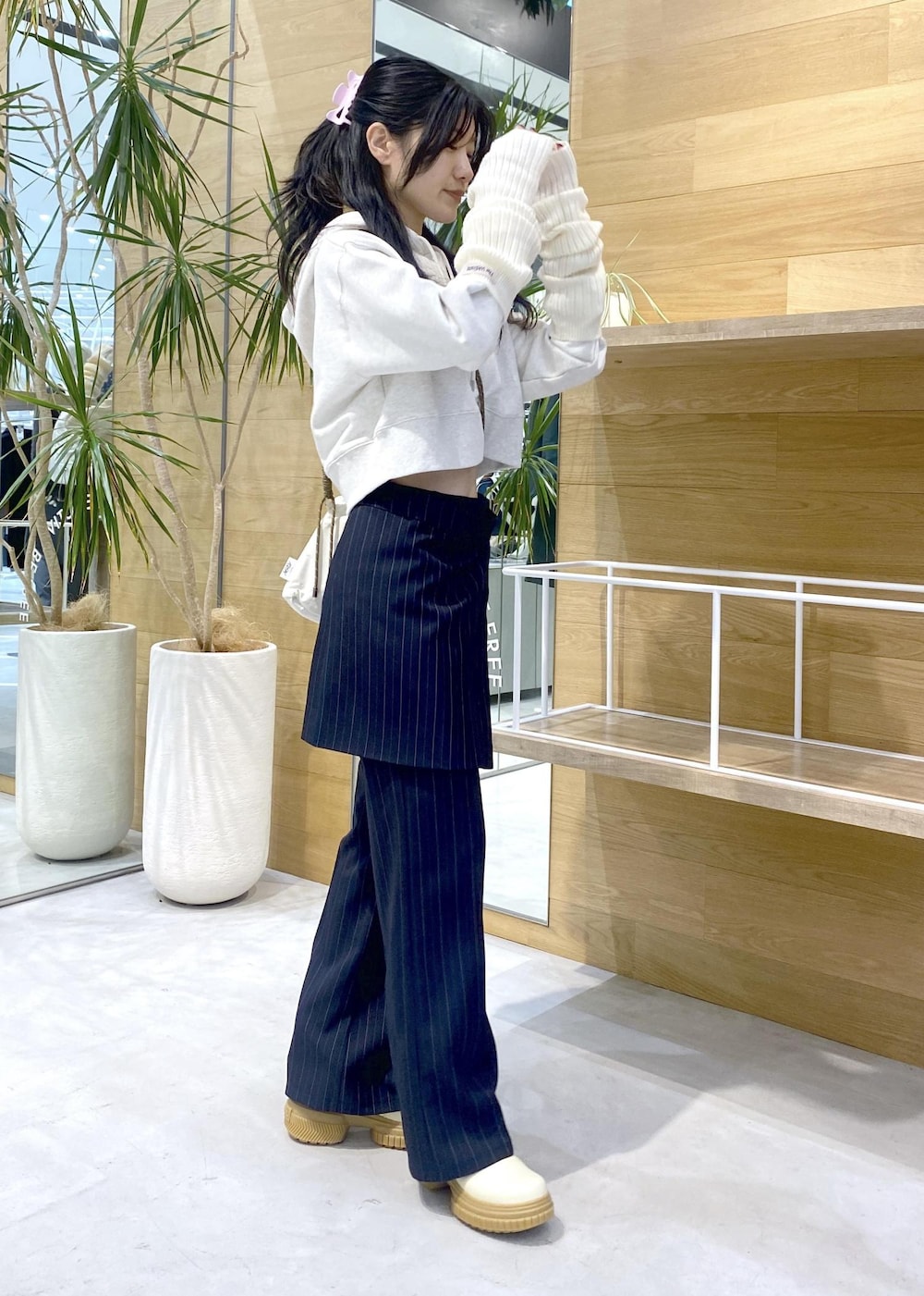 ホワイト系のショルダーバッグ、ホワイト系のブーツ、ホワイト系のパーカーを着用したレディースの冬コーディネートの6枚目の写真