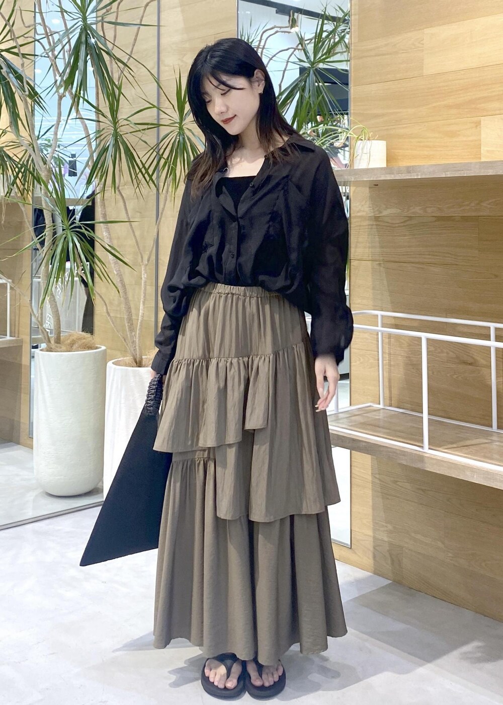 グリーン系のスカート、ブラック系のキャミソール、ブラック系のサンダルを着用したレディースの夏コーディネートの8枚目の写真