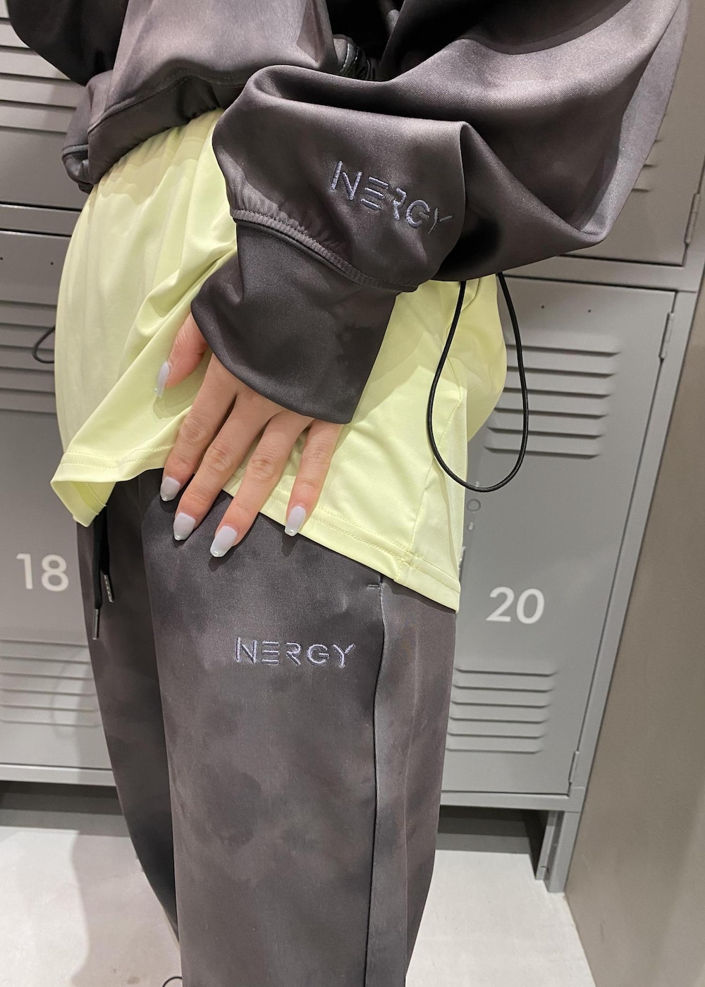 グリーン系のTシャツ/カットソー、ホワイト系のスニーカー、ブラック系のその他パンツを着用したレディースの春コーディネートの5枚目の写真