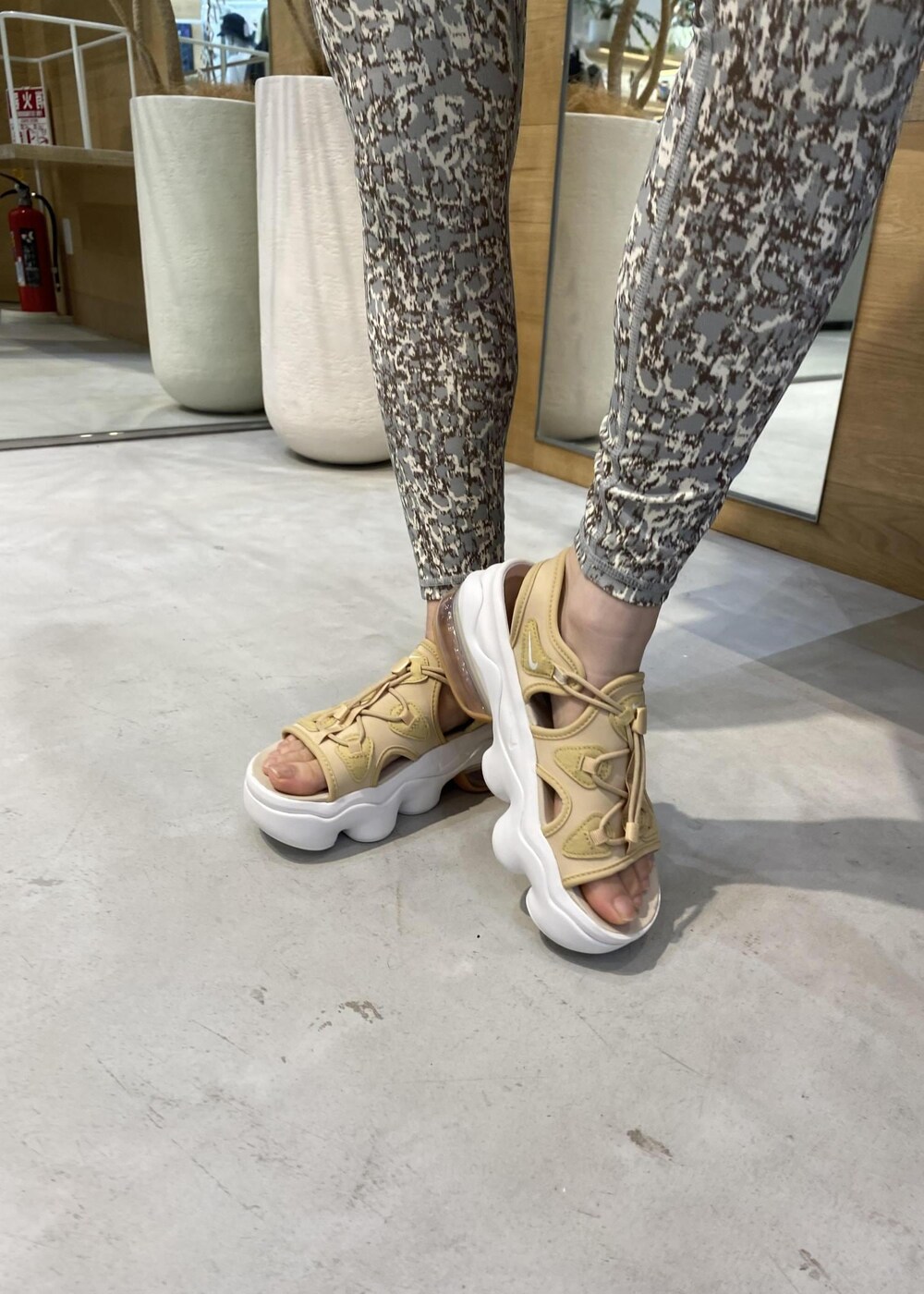 ベージュ系のサンダル、ブラック系のTシャツ/カットソー、グリーン系のレギンス/スパッツを着用したレディースの夏コーディネートの9枚目の写真