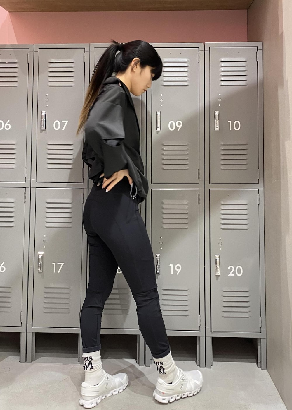 ホワイト系のスニーカー、ブラック系のブルゾン、ホワイト系のブラジャーを着用したレディースの春コーディネートの3枚目の写真