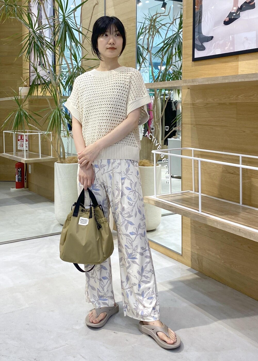 ベージュ系のその他パンツ、ベージュ系のサンダル、ホワイト系のニット/セーターを着用したレディースの夏コーディネートの2枚目の写真