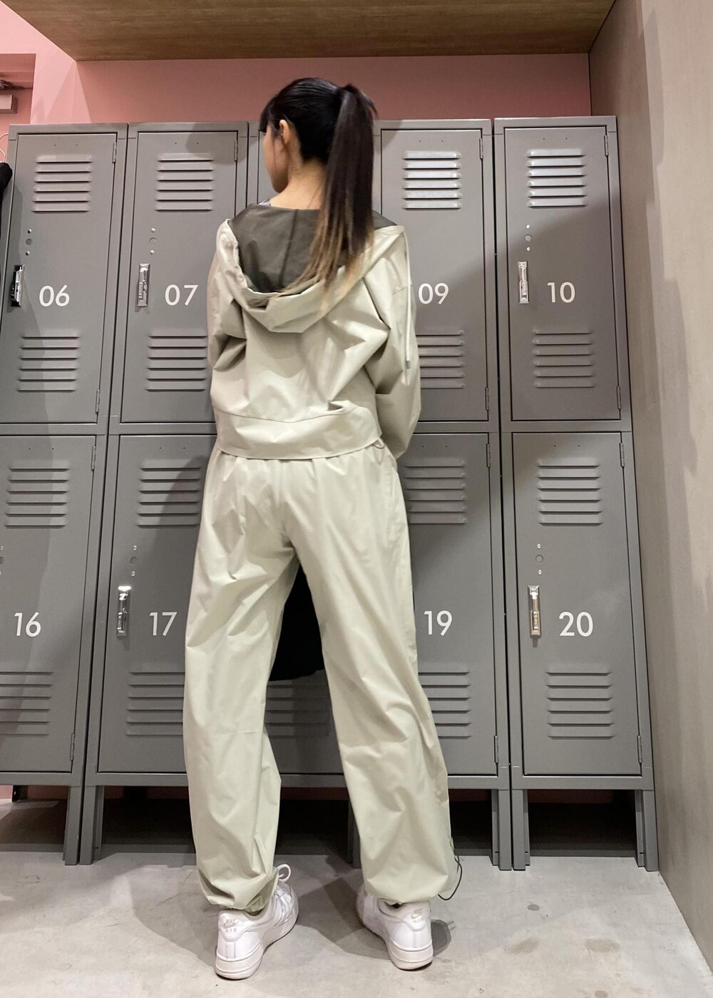 ホワイト系のスニーカー、ブラック系のハンドバッグ、グリーン系のその他パンツを着用したレディースの春コーディネートの3枚目の写真