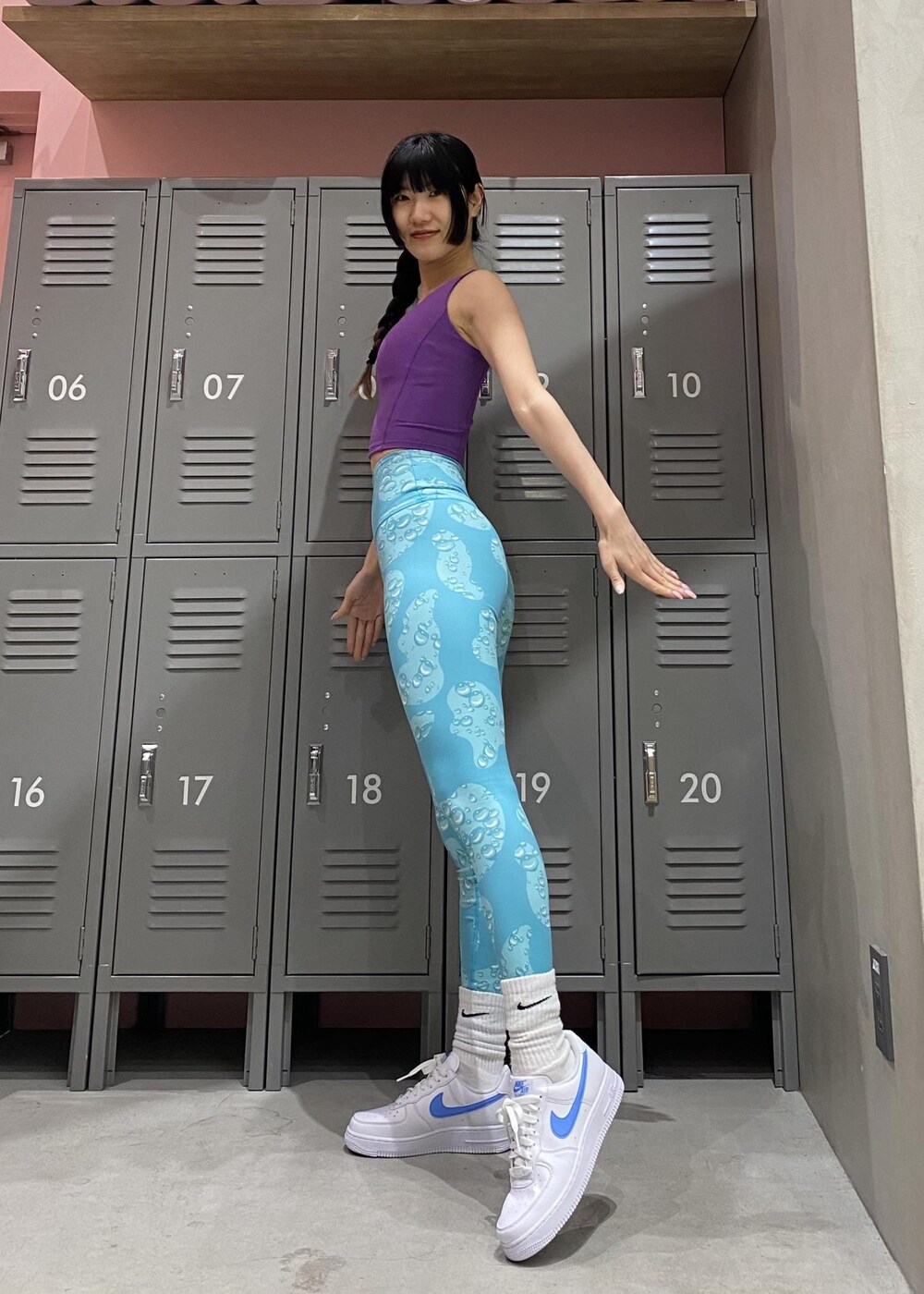 ホワイト系のスニーカー、パープル系のスポーツブラ、ブルー系のレギンス/スパッツを着用したレディースの冬コーディネートの3枚目の写真