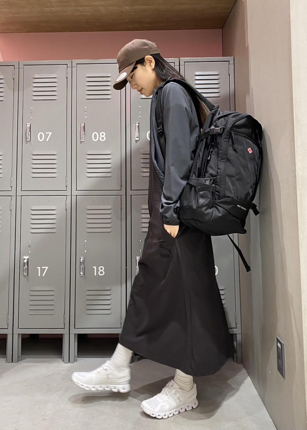 ホワイト系のスニーカー、ブラック系のワンピース、ブラック系のマウンテンパーカーを着用したレディースの春コーディネートの2枚目の写真