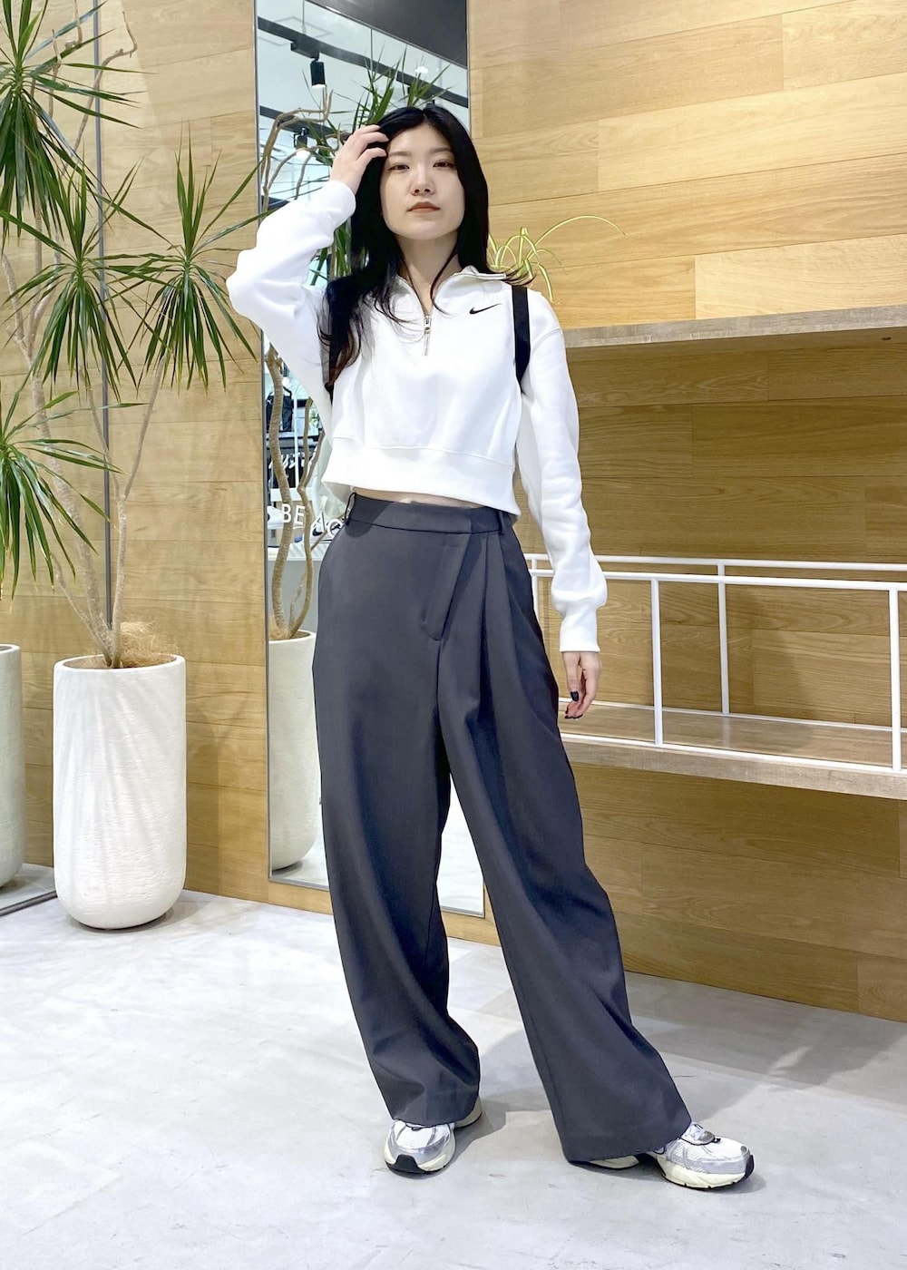 グレー系のスラックス、ホワイト系のスニーカーを着用したレディースの秋コーディネートの2枚目の写真