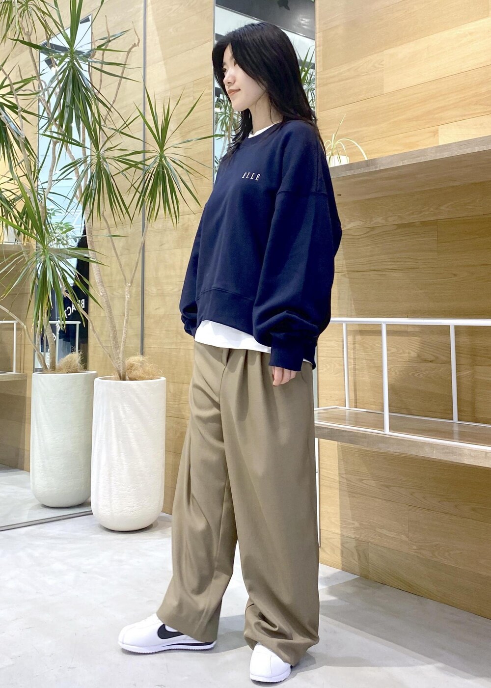 ホワイト系のスニーカー、ホワイト系のTシャツ/カットソー、ブルー系のスウェットを着用したレディースの秋コーディネートの7枚目の写真