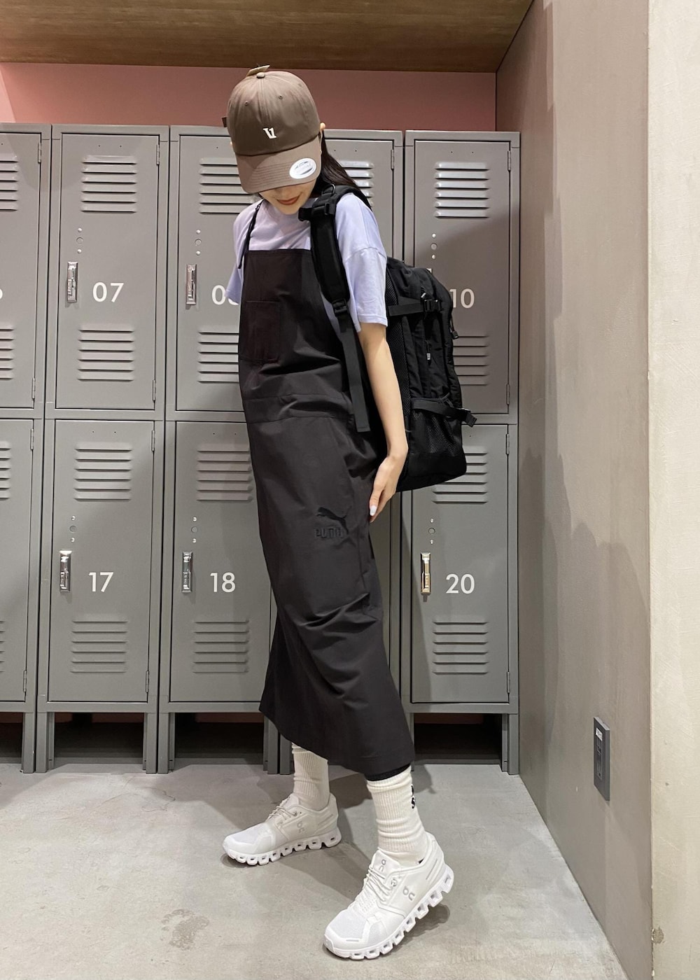 ホワイト系のスニーカー、ブラック系のワンピース、ブラック系のマウンテンパーカーを着用したレディースの春コーディネートの4枚目の写真