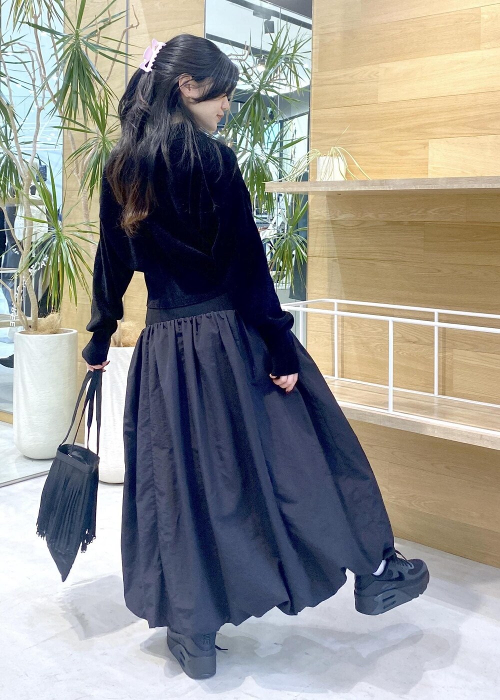 ブラック系のスカート、ブラック系のカーディガン/ボレロ、ブラック系のスニーカーを着用したレディースの冬コーディネートの6枚目の写真