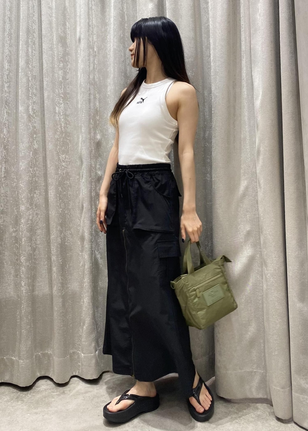 ブラック系のサンダル、ブラック系のスカート、ホワイト系のタンクトップを着用したレディースの春コーディネートの2枚目の写真