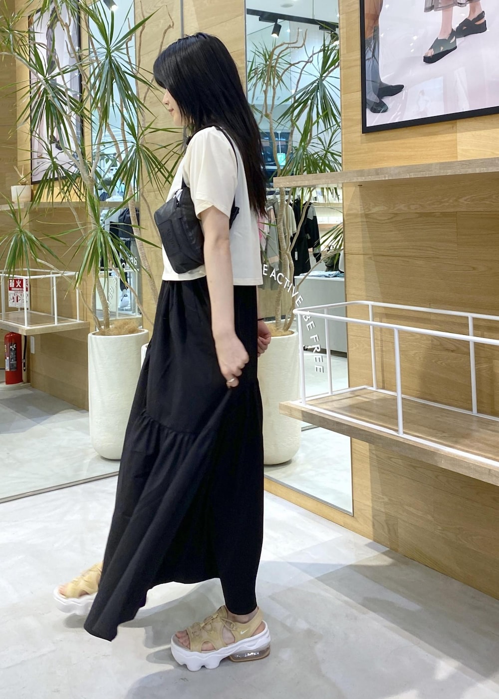 ベージュ系のサンダル、ホワイト系のTシャツ/カットソー、ブラック系のボディバッグ/ウエストポーチを着用したレディースの夏コーディネートの3枚目の写真