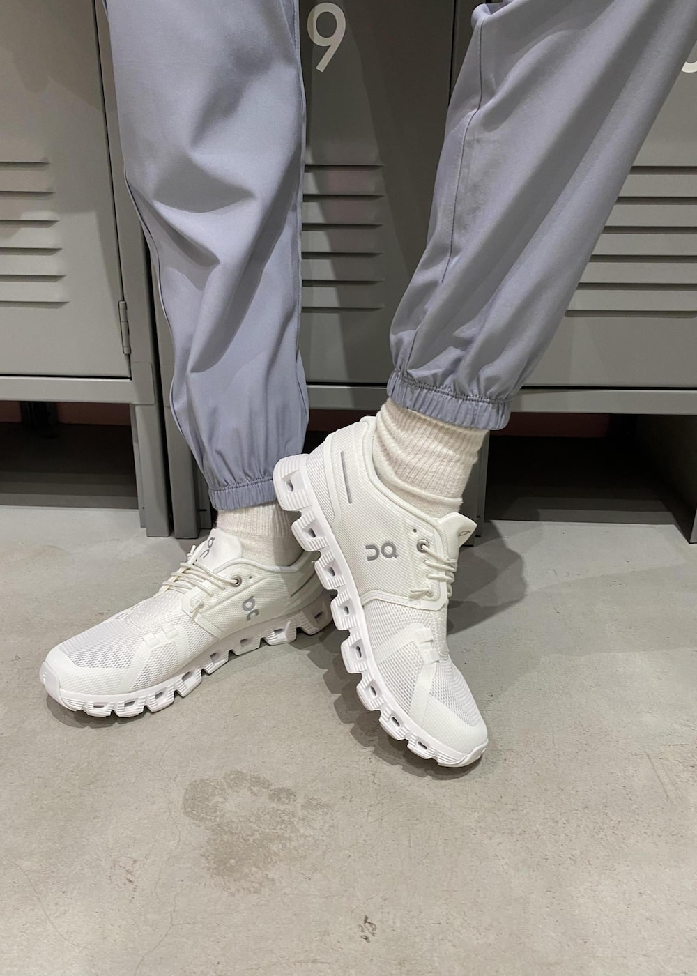 ホワイト系のスニーカー、ブラック系のブルゾン、ホワイト系のブラジャーを着用したレディースの春コーディネートの4枚目の写真