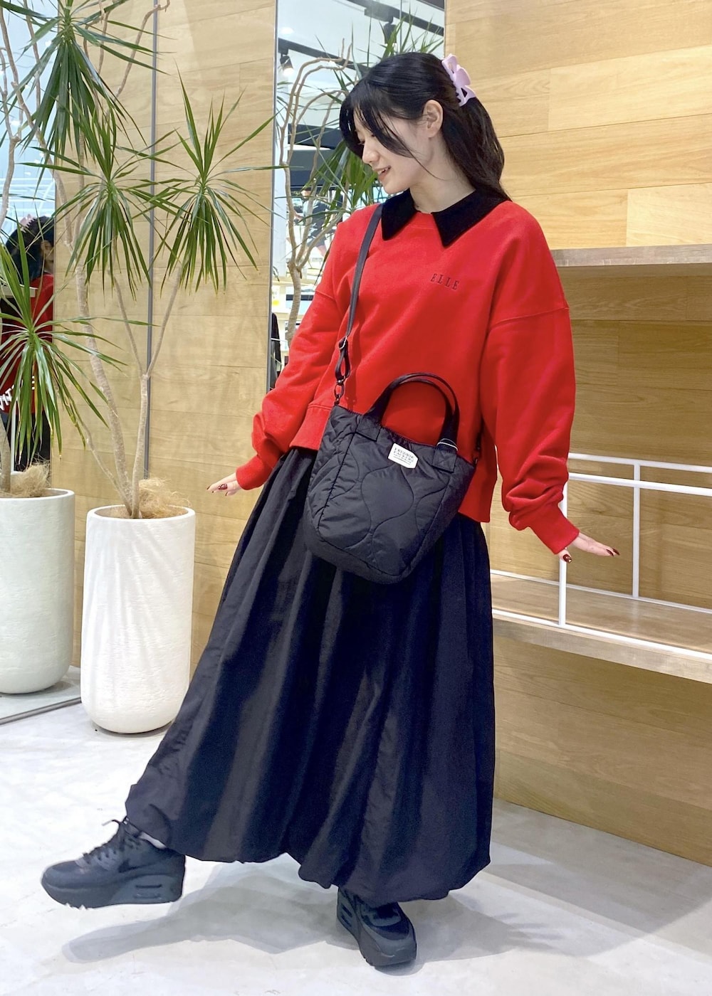 ブラック系のカーディガン/ボレロ、ブラック系のスニーカー、レッド系のスウェットを着用したレディースの冬コーディネートの3枚目の写真