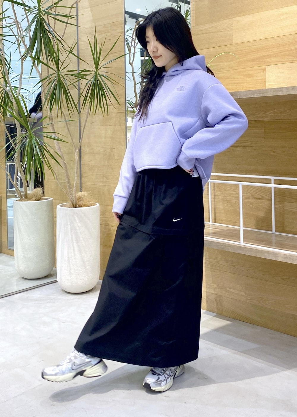 ホワイト系のスニーカー、パープル系のパーカー、ブラック系のスカートを着用したレディースの秋コーディネートの2枚目の写真