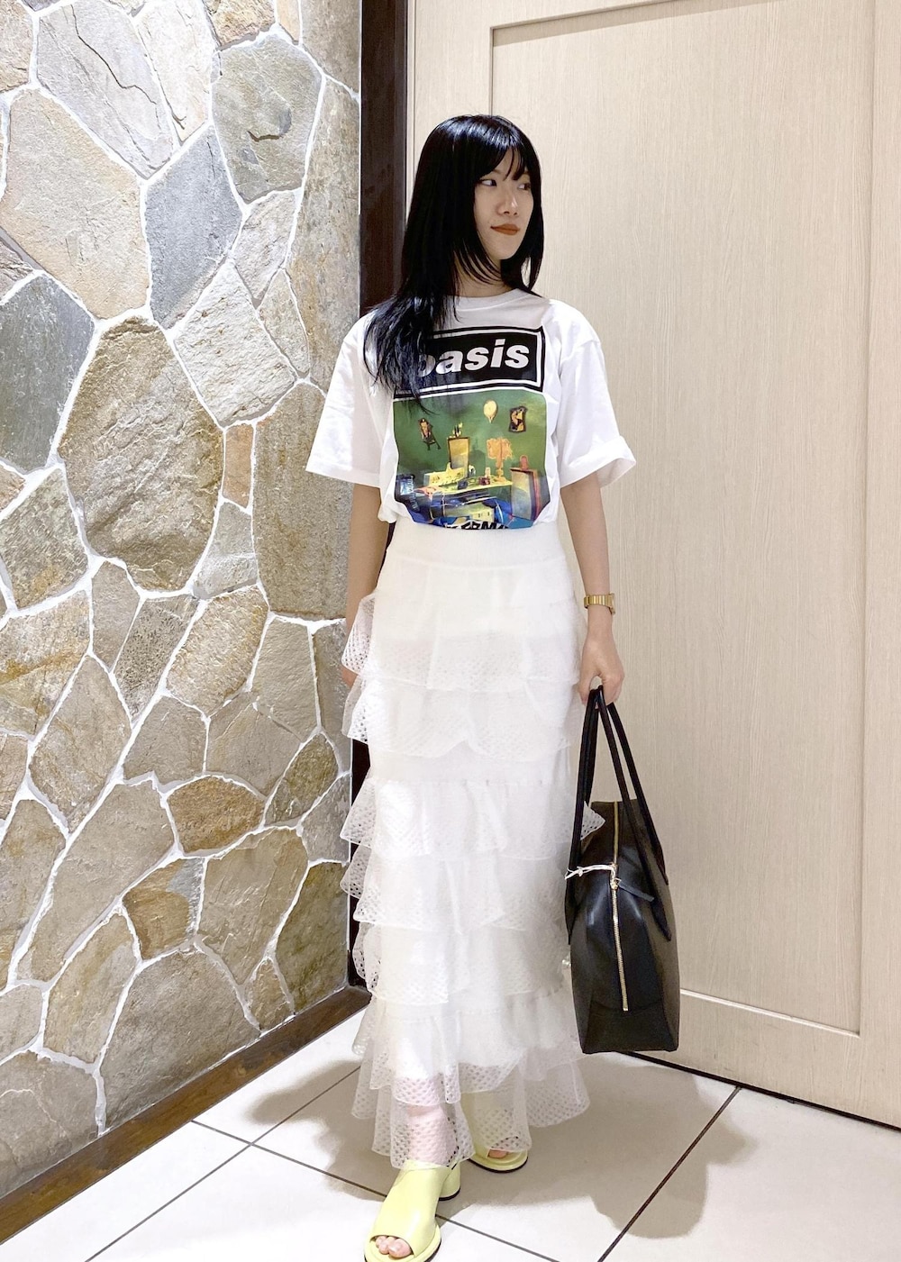 グリーン系のサンダル、ホワイト系のスカート、ブラック系のボストンバッグを着用したレディースの夏コーディネートの2枚目の写真