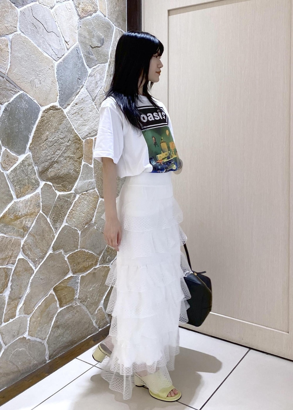 グリーン系のサンダル、ホワイト系のスカート、ブラック系のボストンバッグを着用したレディースの夏コーディネートの3枚目の写真