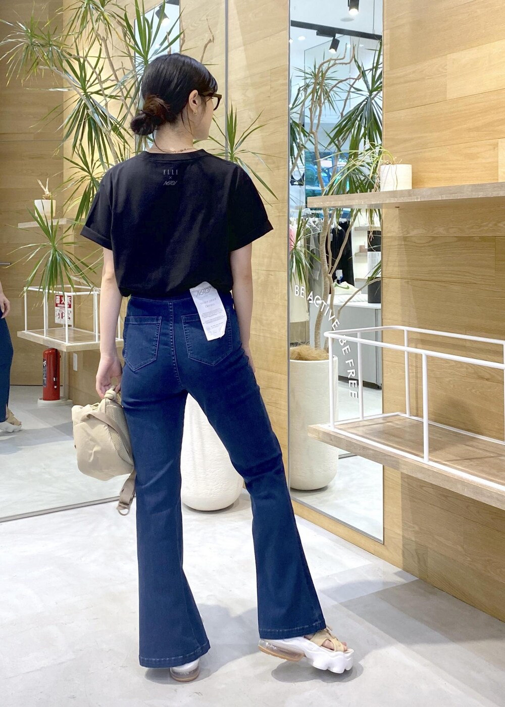 ブルー系のデニムパンツ、ベージュ系のサンダル、ブラック系のTシャツ/カットソーを着用したレディースの夏コーディネートの5枚目の写真