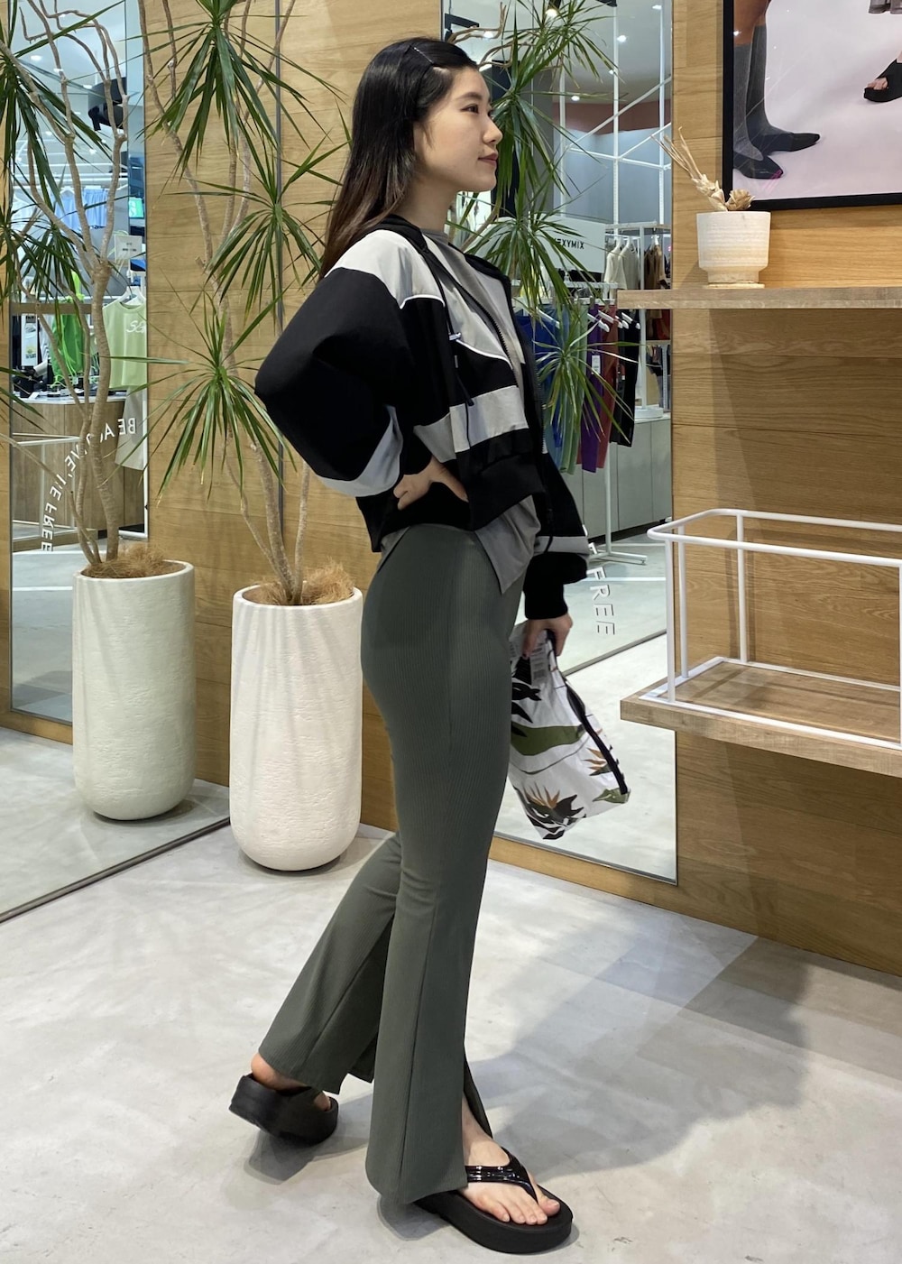 ブラック系のサンダル、グリーン系のカーゴパンツ、ブラック系のブルゾンを着用したレディースの夏コーディネートの2枚目の写真