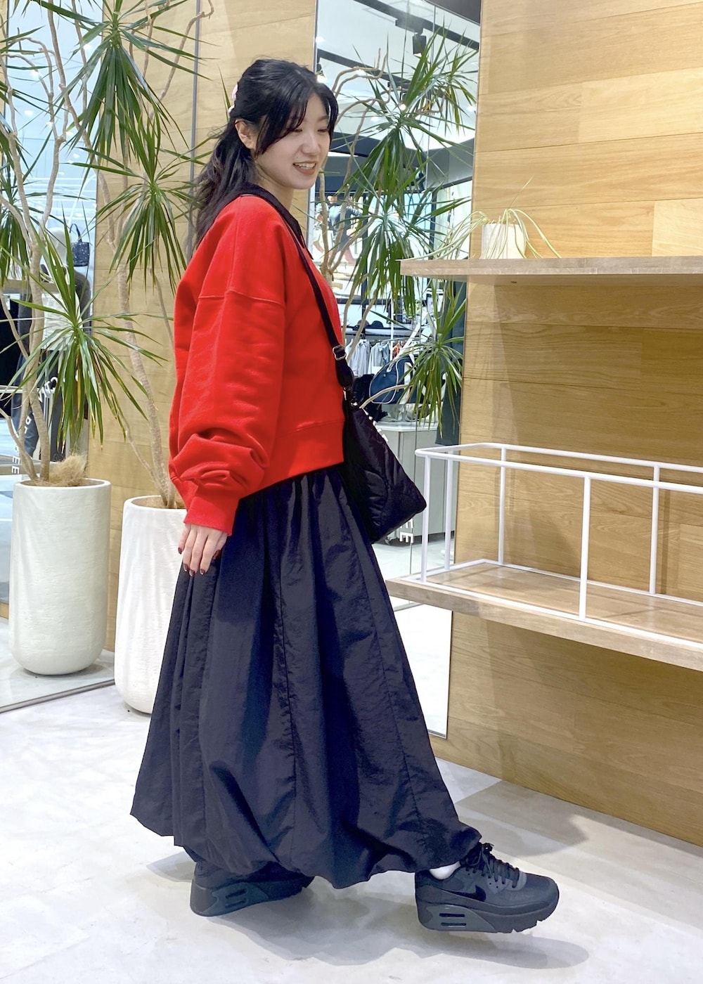 ブラック系のカーディガン/ボレロ、ブラック系のスニーカー、レッド系のスウェットを着用したレディースの冬コーディネートの6枚目の写真