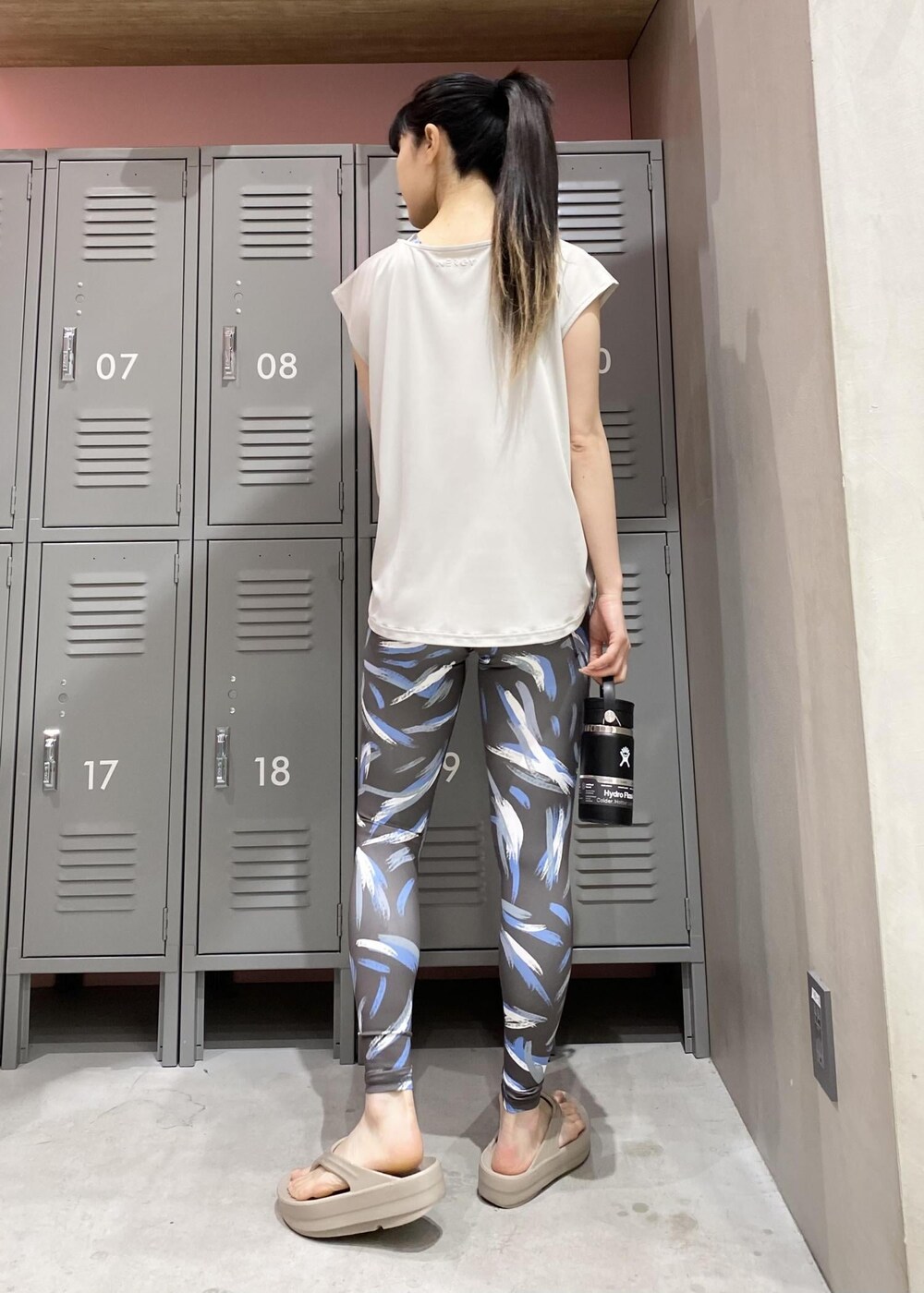 グレー系のTシャツ/カットソー、ベージュ系のサンダル、ブラック系のスポーツブラを着用したレディースの春コーディネートの3枚目の写真