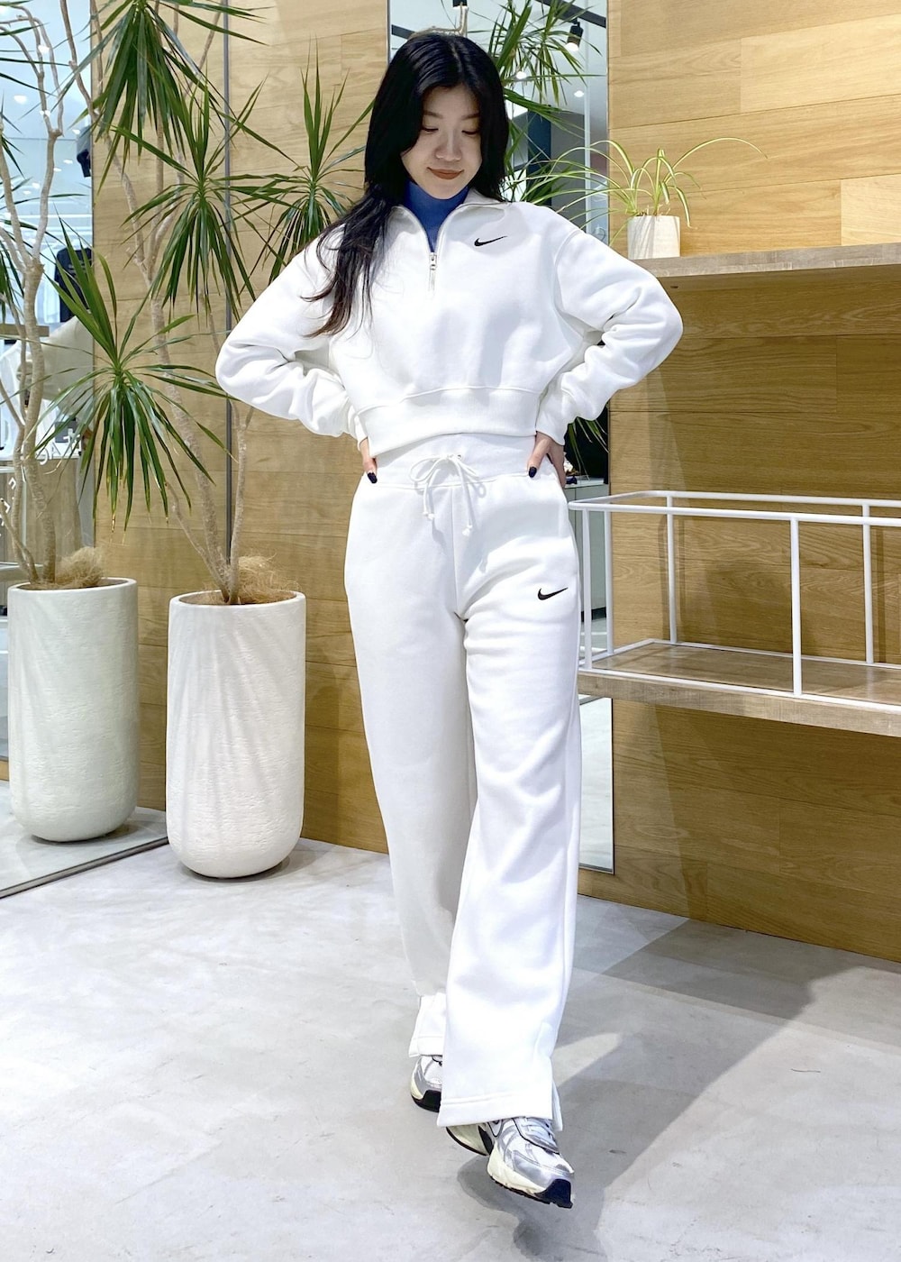 ホワイト系のスニーカー、ブルー系のニット/セーター、ブラック系のその他パンツを着用したレディースの秋コーディネートの6枚目の写真