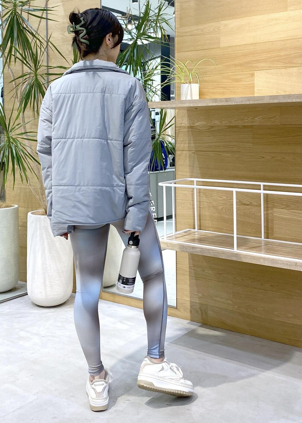 グリーン系のダウンジャケット/コート、ブルー系のレギンス/スパッツを着用したレディースの秋コーディネートの4枚目の写真