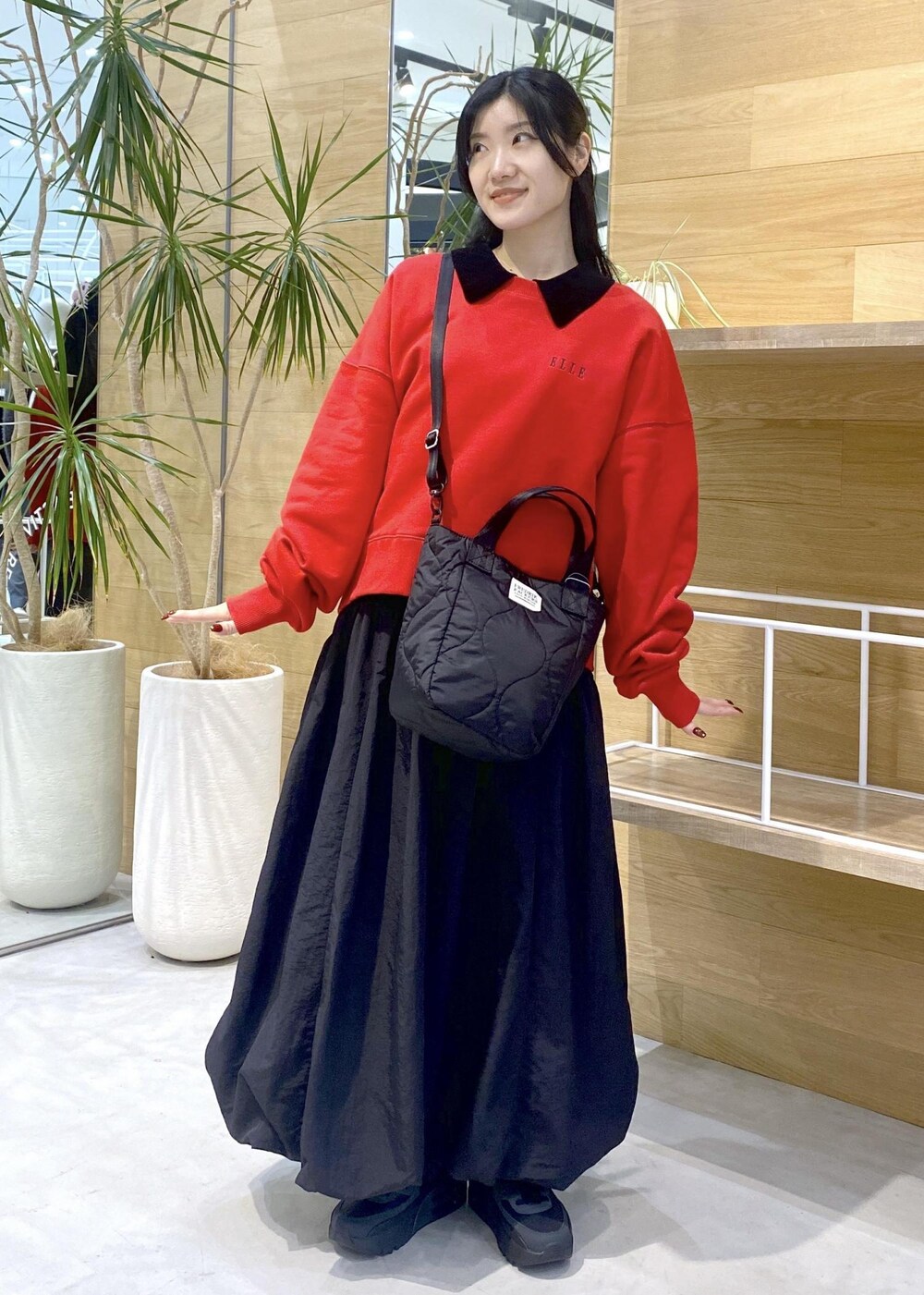 ブラック系のカーディガン/ボレロ、ブラック系のスニーカー、レッド系のスウェットを着用したレディースの冬コーディネートの2枚目の写真