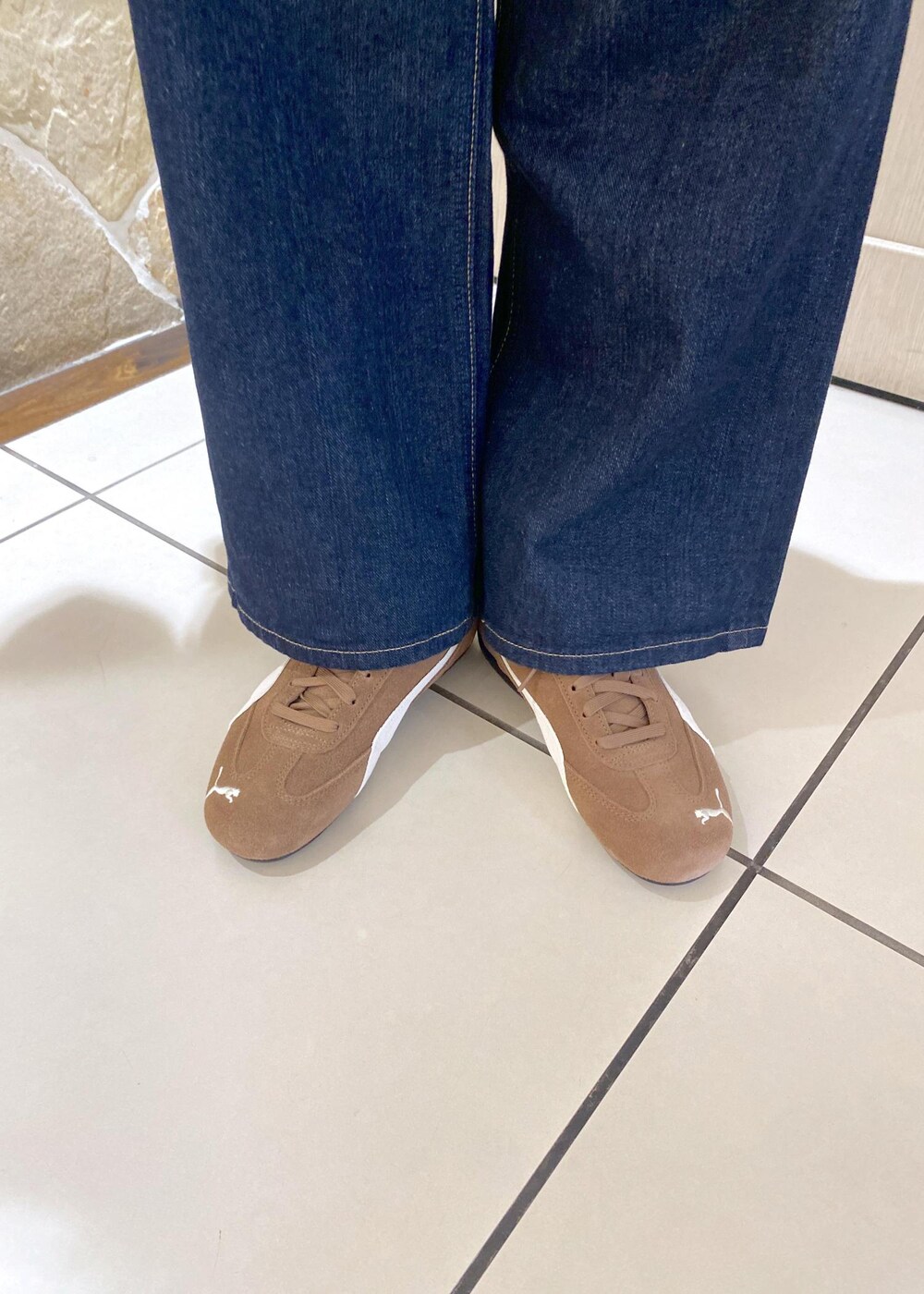 ベージュ系のスニーカー、ブルー系のデニムパンツ、ベージュ系のショルダーバッグを着用したレディースの夏コーディネートの7枚目の写真