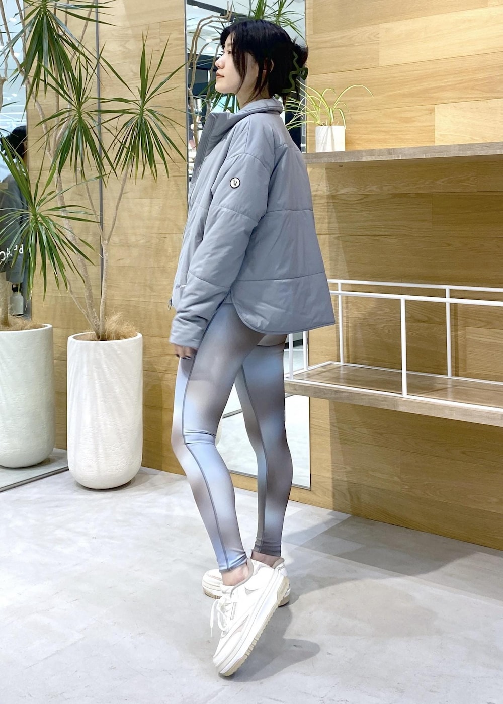 グリーン系のダウンジャケット/コート、ブルー系のレギンス/スパッツを着用したレディースの秋コーディネートの3枚目の写真