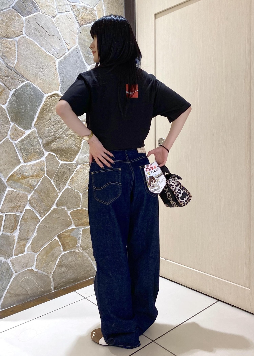 ベージュ系のスニーカー、ブルー系のデニムパンツ、ベージュ系のショルダーバッグを着用したレディースの夏コーディネートの4枚目の写真