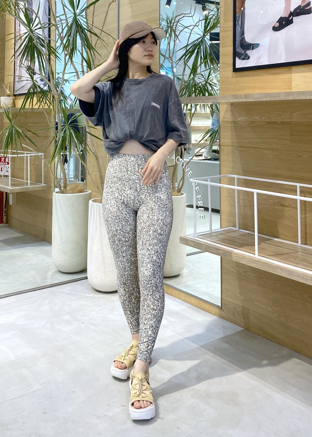 ベージュ系のサンダル、ブラック系のTシャツ/カットソー、グリーン系のレギンス/スパッツを着用したレディースの夏コーディネートの2枚目の写真