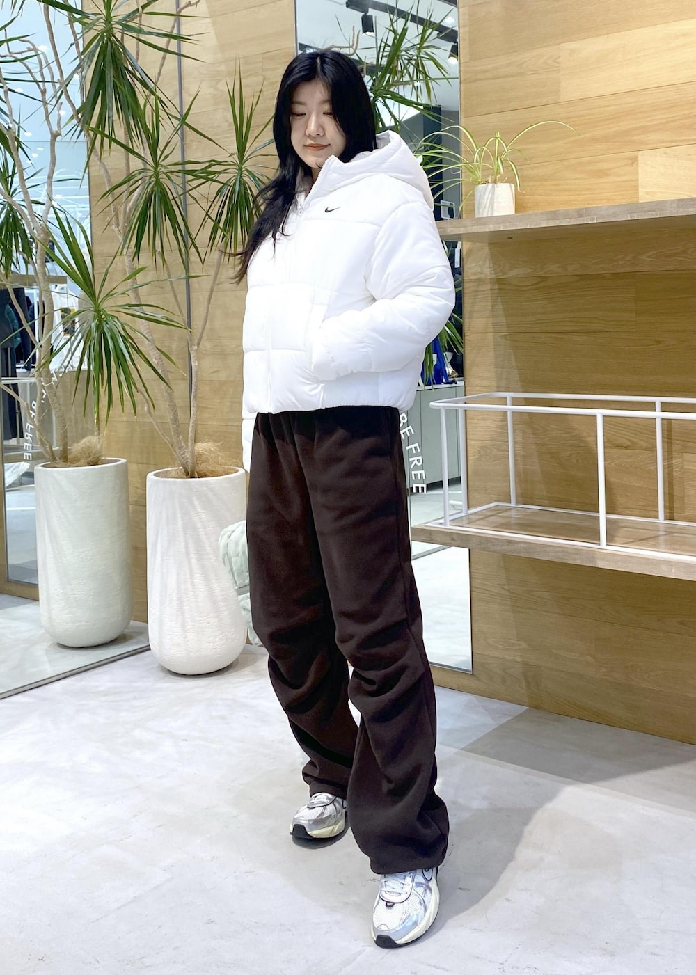 ブラウン系のその他パンツ、ホワイト系のスニーカー、ホワイト系のダウンジャケット/コートを着用したレディースの秋コーディネートの7枚目の写真