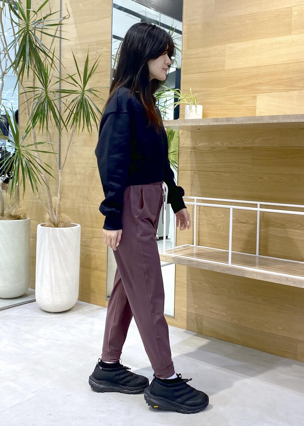 ピンク系のスラックス、ブラック系のスニーカー、ブラック系のスウェットを着用したレディースの秋コーディネートの3枚目の写真