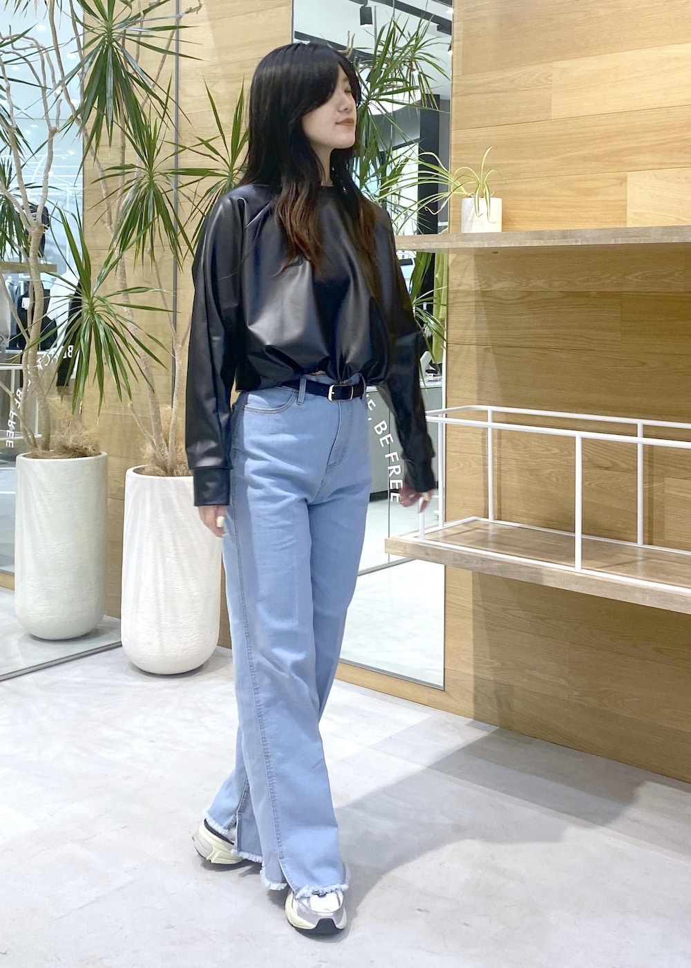 ブラック系のその他トップス、ブルー系のデニムパンツ、ホワイト系のスニーカーを着用したレディースの秋コーディネートの7枚目の写真