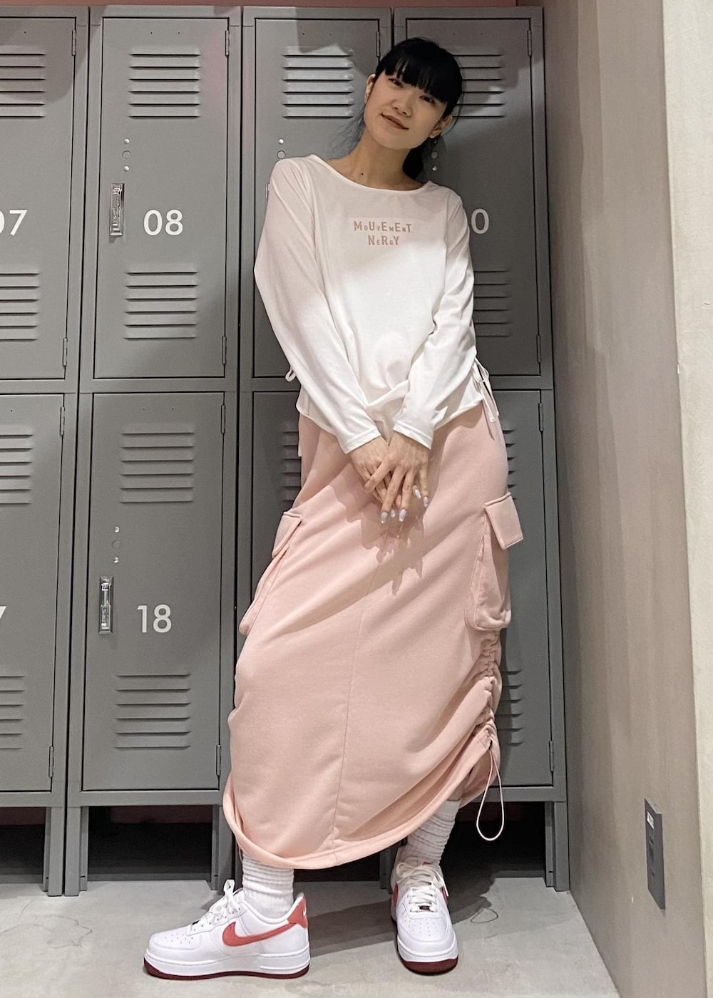 ピンク系のスカート、ホワイト系のTシャツ/カットソー、ホワイト系のスニーカーを着用したレディースの冬コーディネートの3枚目の写真