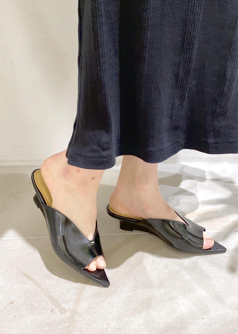 ブラック系のハンドバッグ、ブラック系のサンダル、ブラック系のスカートを着用したレディースの夏コーディネートの6枚目の写真