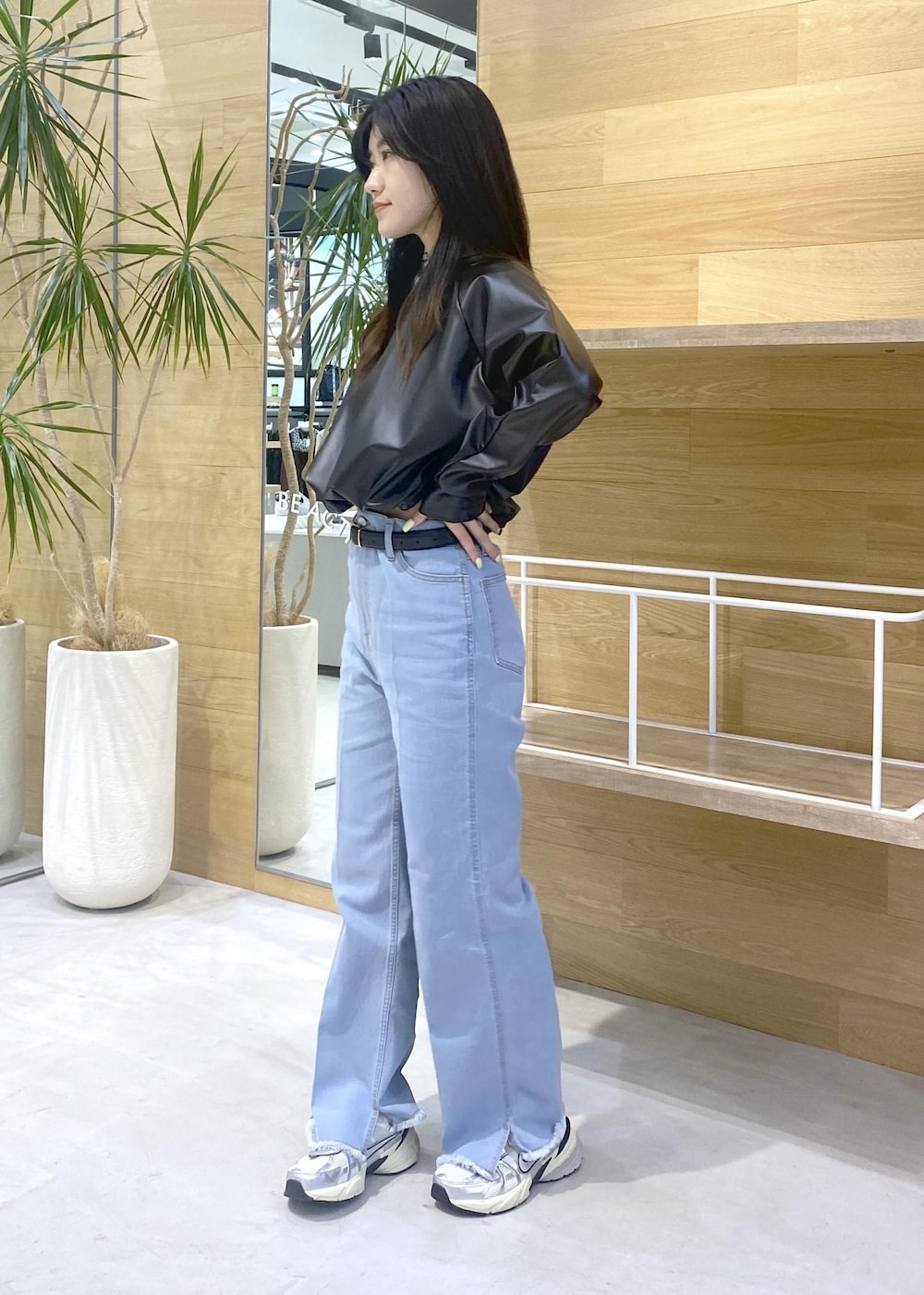 ブラック系のその他トップス、ブルー系のデニムパンツ、ホワイト系のスニーカーを着用したレディースの秋コーディネートの2枚目の写真