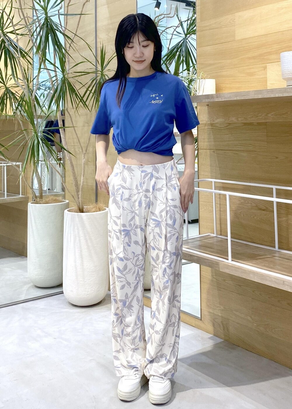 ベージュ系のその他パンツ、ホワイト系のスニーカー、ブルー系のTシャツ/カットソーを着用したレディースの夏コーディネートの2枚目の写真