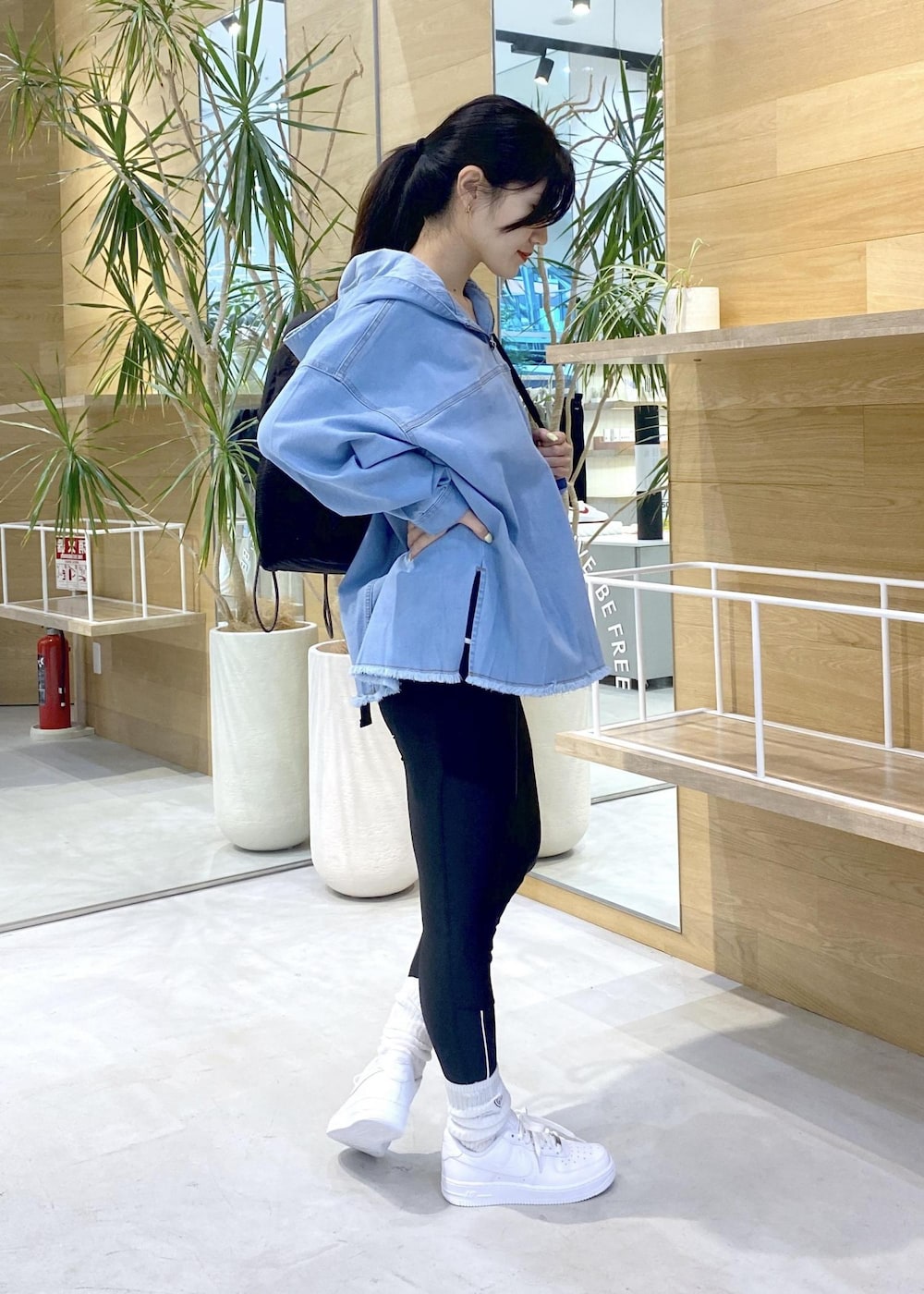 ホワイト系のスニーカー、ブルー系のパーカー、ブラック系のバックパック/リュックを着用したレディースの秋コーディネートの2枚目の写真