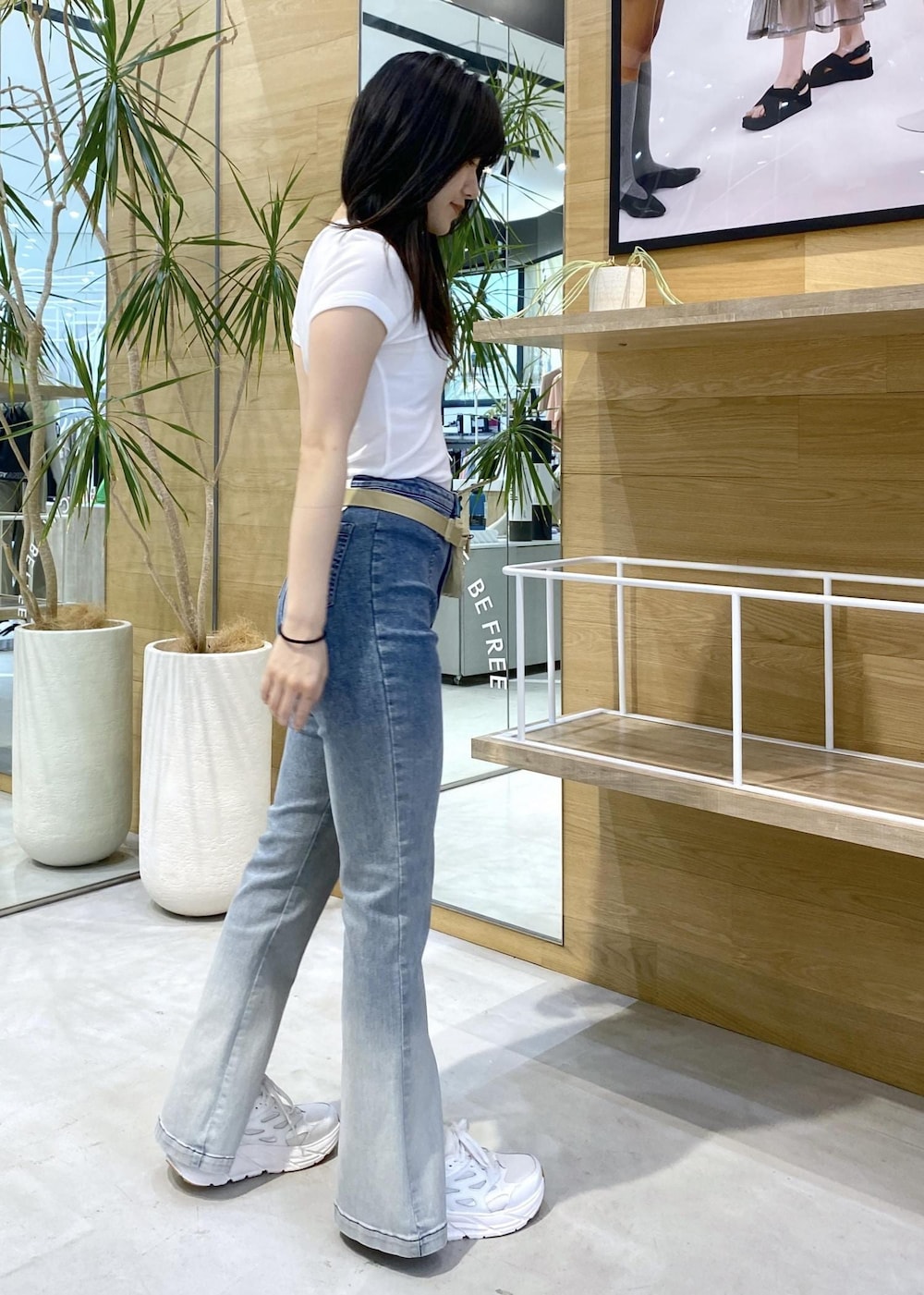 ブルー系のデニムパンツ、ホワイト系のスニーカー、ホワイト系のTシャツ/カットソーを着用したレディースの夏コーディネートの5枚目の写真