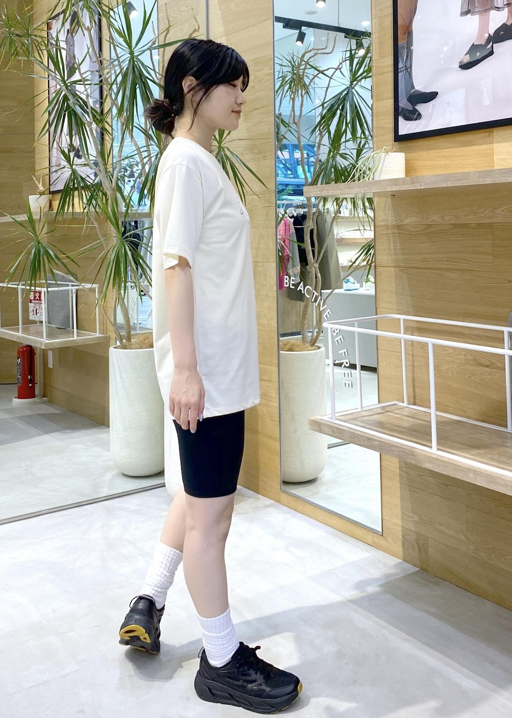 ホワイト系のTシャツ/カットソー、ブラック系のスニーカー、ブラック系のレギンス/スパッツを着用したレディースの夏コーディネートの4枚目の写真