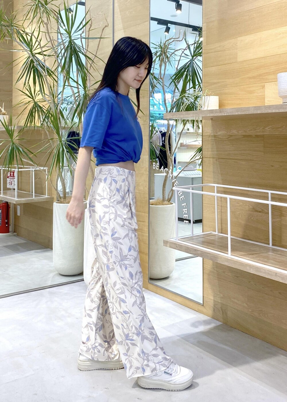 ベージュ系のその他パンツ、ホワイト系のスニーカー、ブルー系のTシャツ/カットソーを着用したレディースの夏コーディネートの6枚目の写真