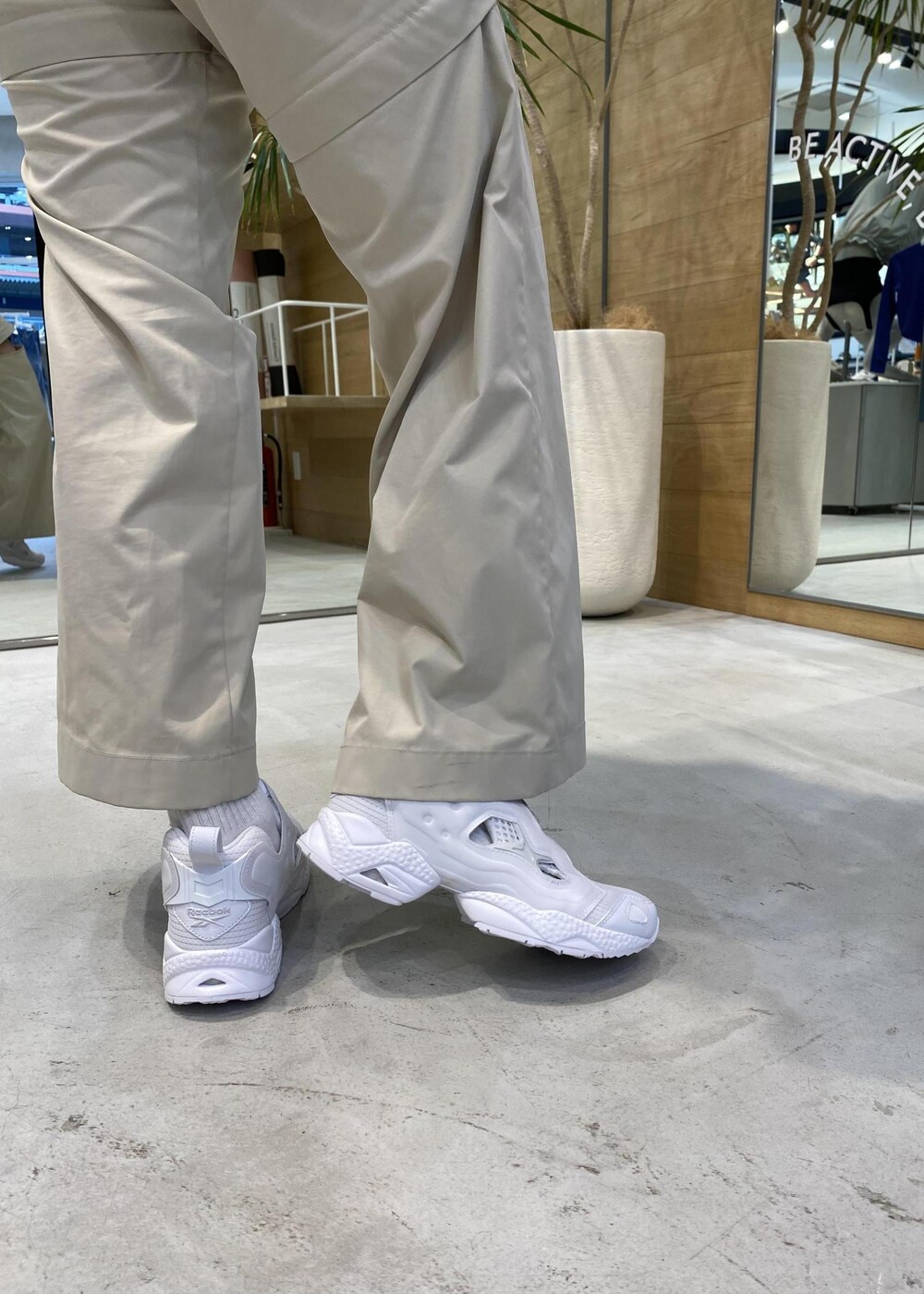 ブラック系のカーゴパンツ、ホワイト系のスニーカー、ホワイト系のタンクトップを着用したレディースの春コーディネートの8枚目の写真