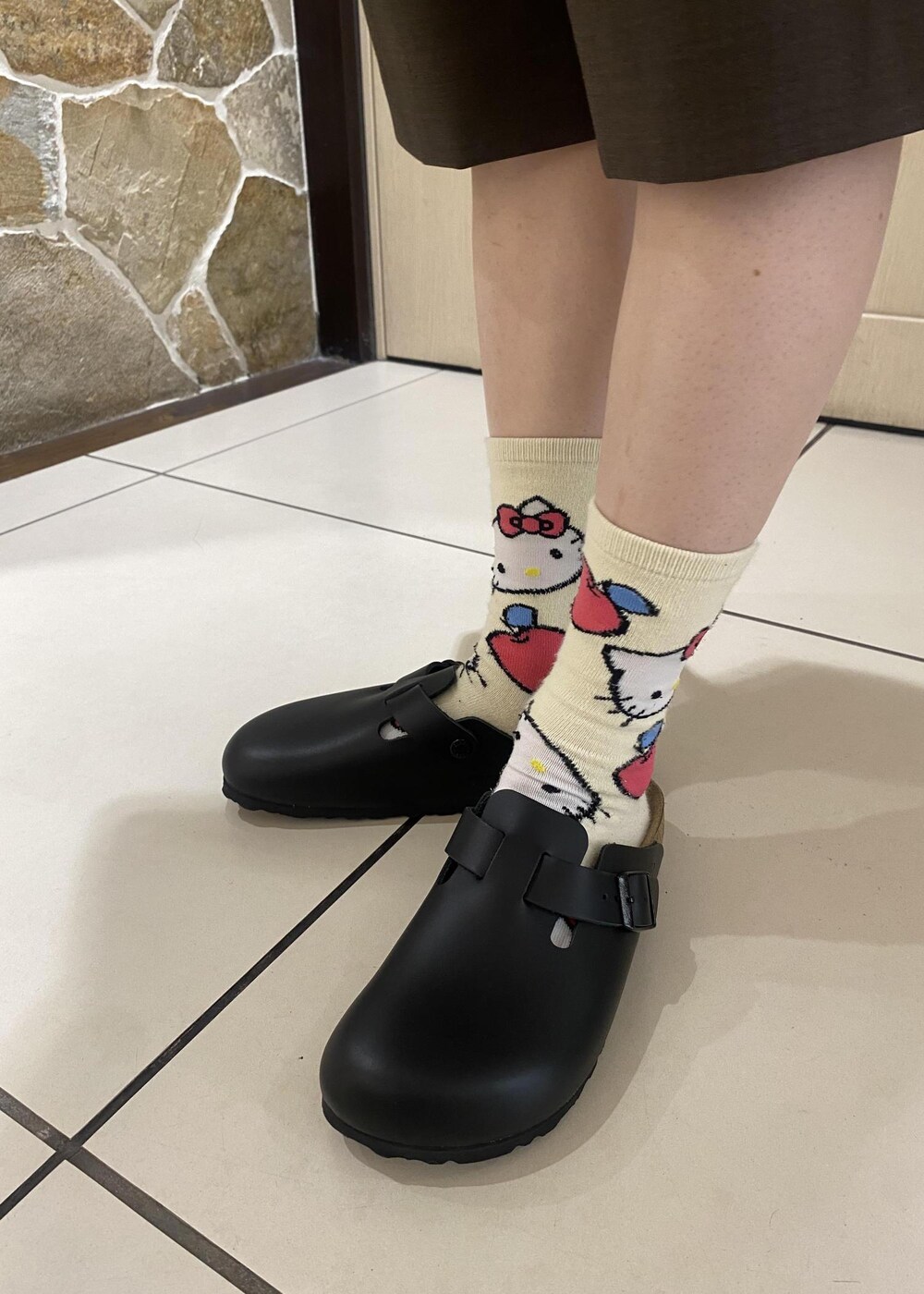 ブラウン系のバックパック/リュック、ブラウン系のその他パンツ、ベージュ系のポロシャツを着用したレディースの春コーディネートの9枚目の写真