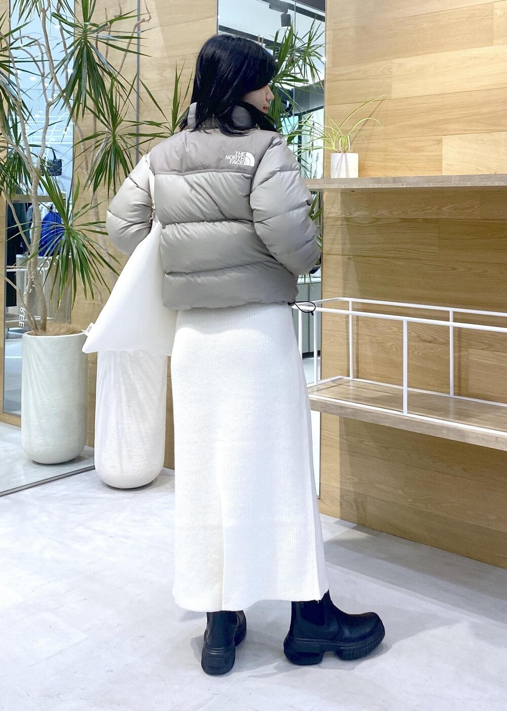ホワイト系のトートバッグ、ベージュ系のダウンジャケット/コートを着用したレディースの秋コーディネートの5枚目の写真