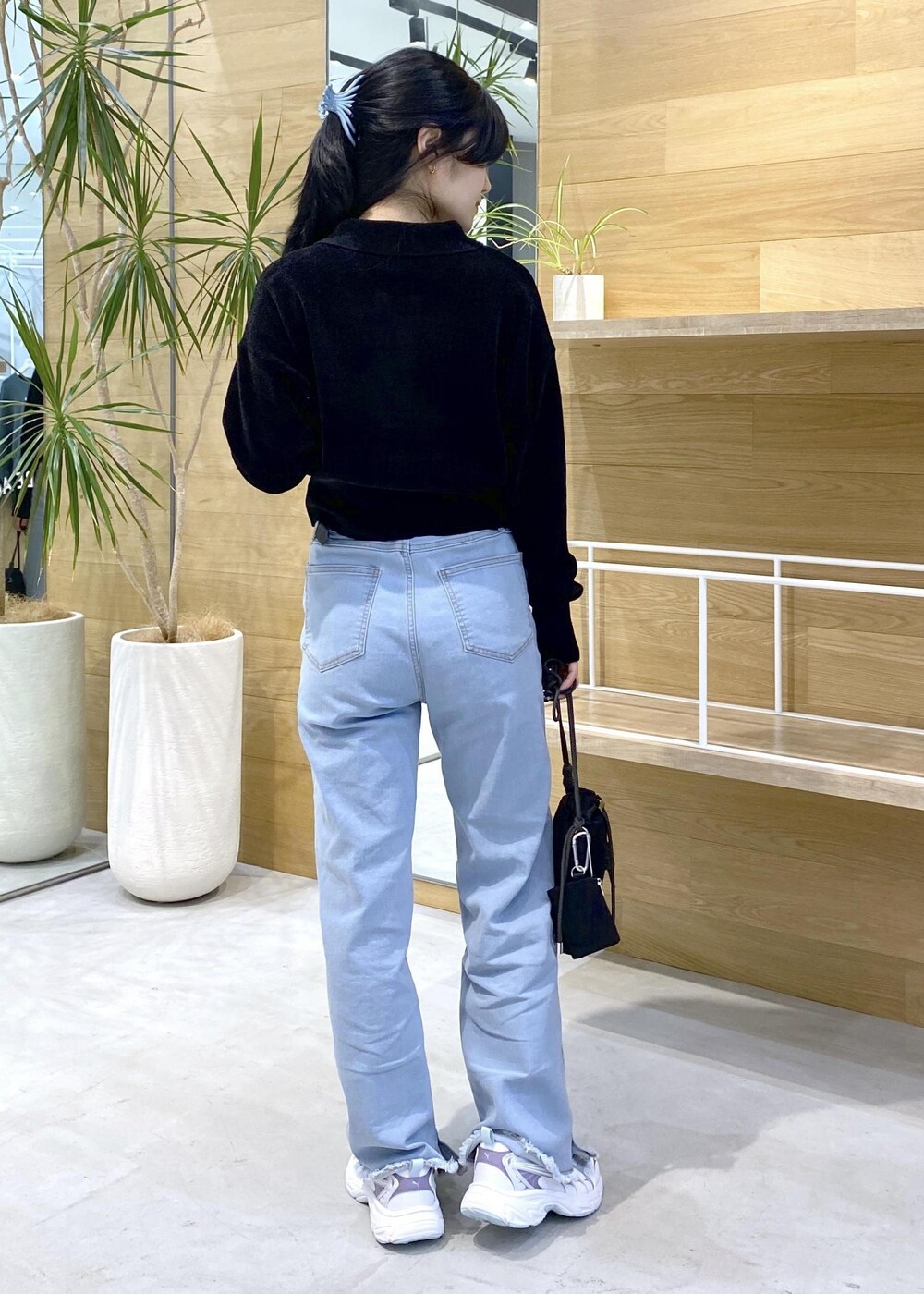 ブルー系のデニムパンツ、ブラック系のショルダーバッグ、ブラック系のカーディガン/ボレロを着用したレディースの秋コーディネートの5枚目の写真