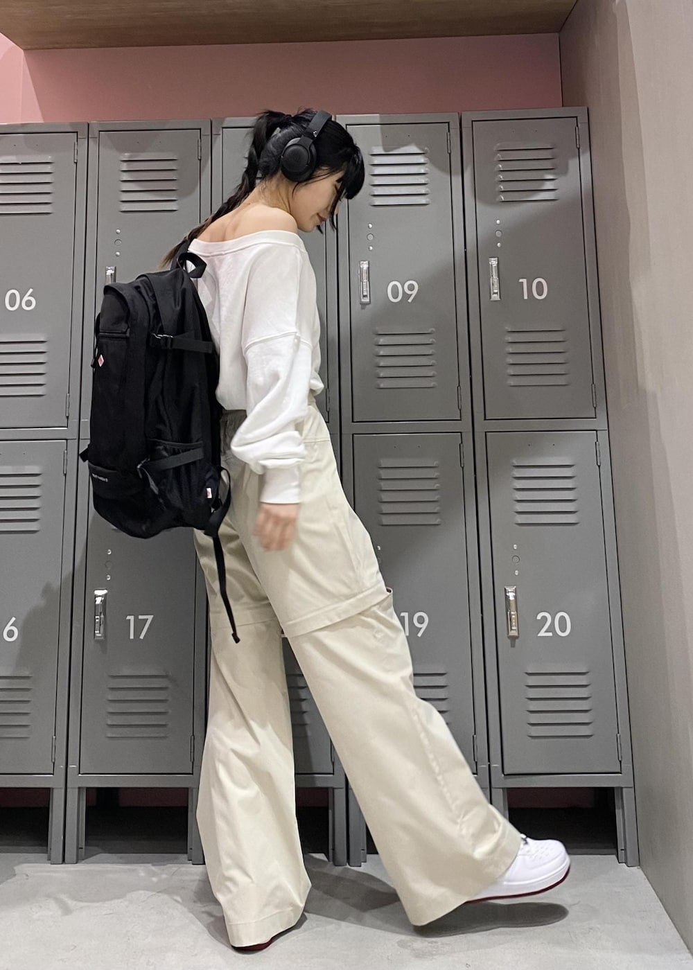 ホワイト系のTシャツ/カットソー、ホワイト系のスニーカー、ブラック系のバックパック/リュックを着用したレディースの冬コーディネートの2枚目の写真