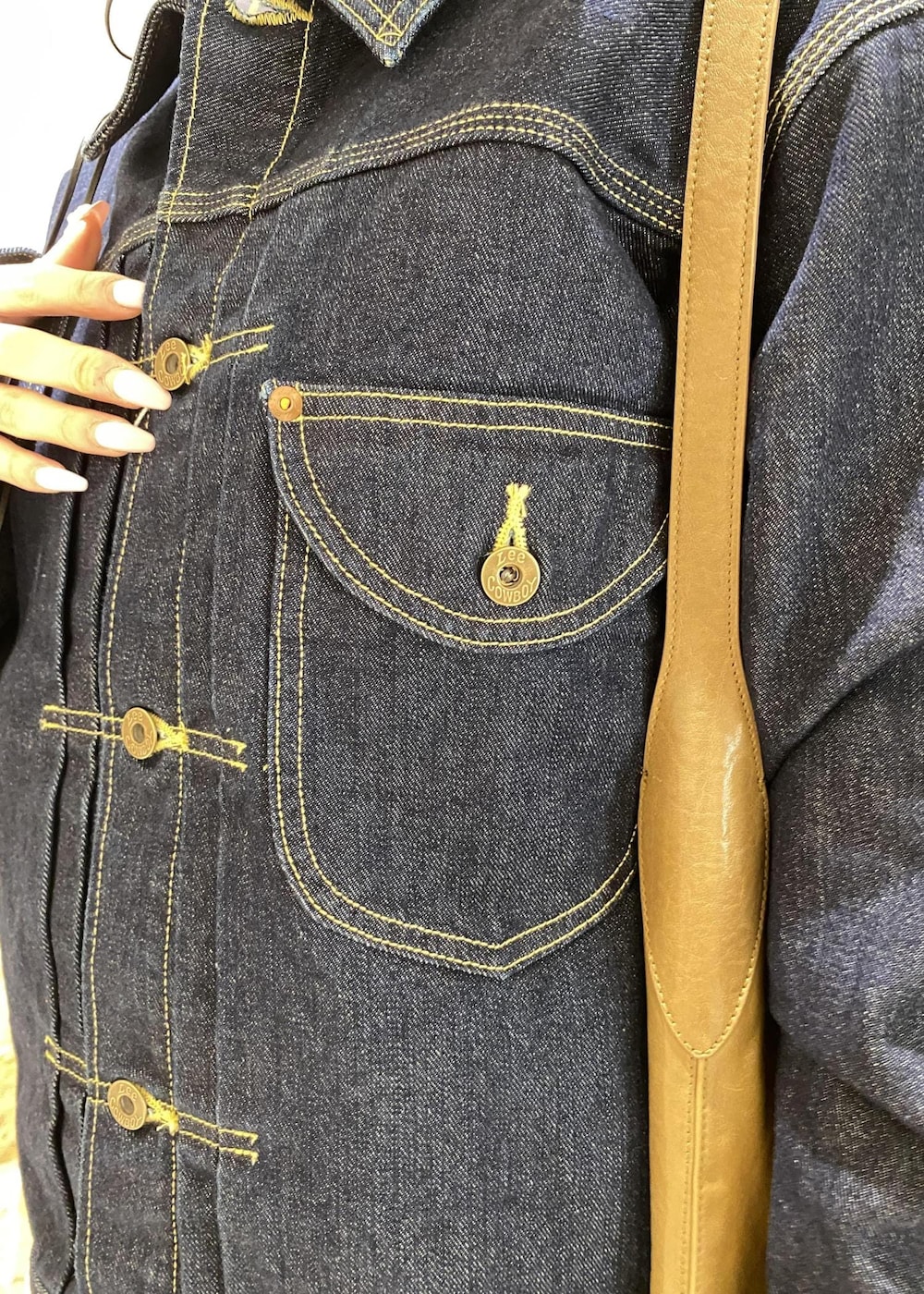 グリーン系のショルダーバッグ、ブルー系のデニムジャケット、ホワイト系のその他パンツを着用したレディースの冬コーディネートの6枚目の写真