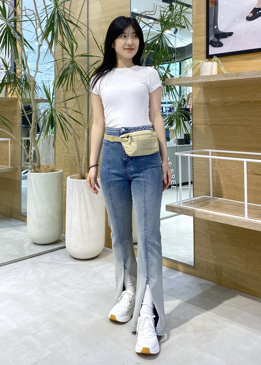 ブルー系のデニムパンツ、ホワイト系のスニーカー、ホワイト系のTシャツ/カットソーを着用したレディースの夏コーディネートの2枚目の写真